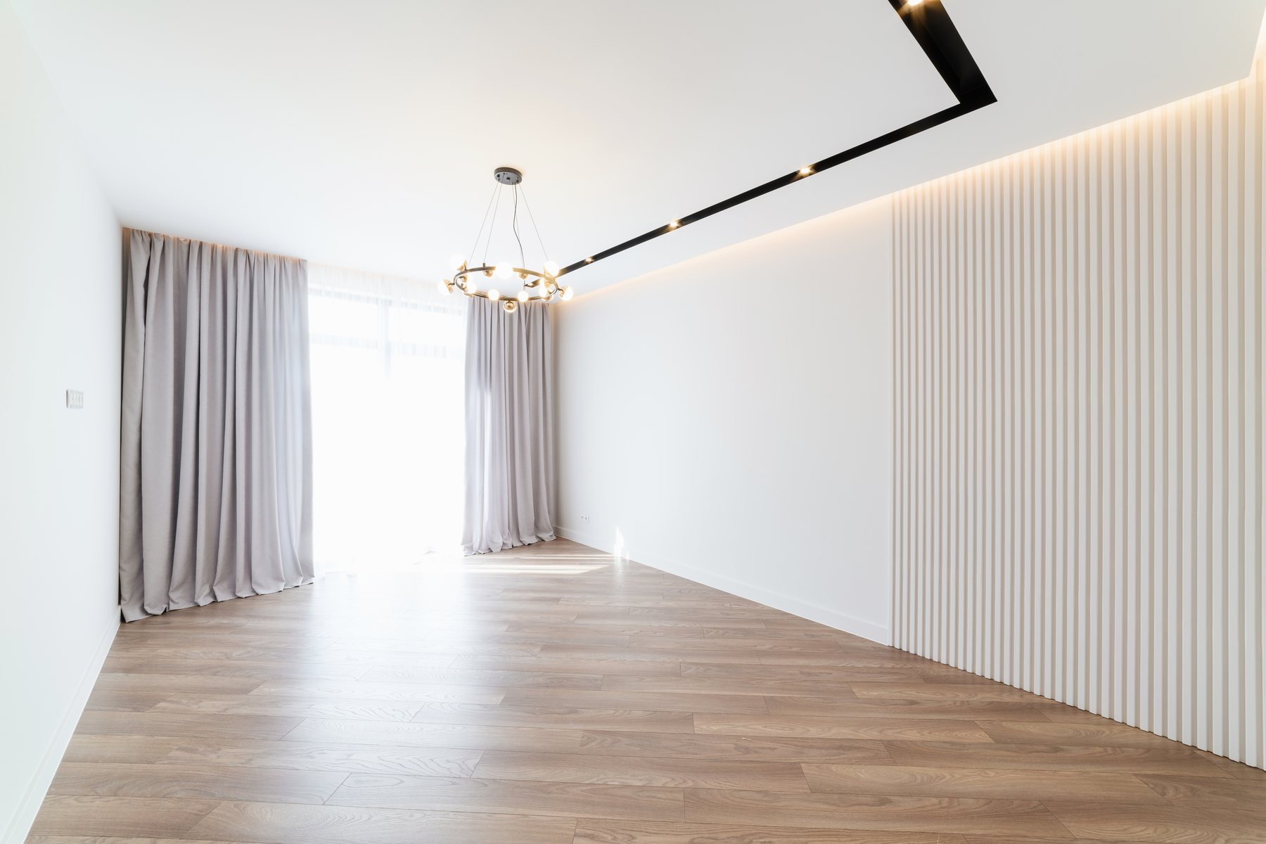 Fertiggestellter weißer Wohnraum mit großer Fensterfront